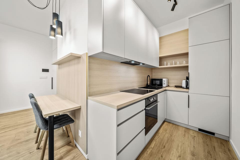 Modern kitchenette with dining bar, sleek finishes, and smart storage