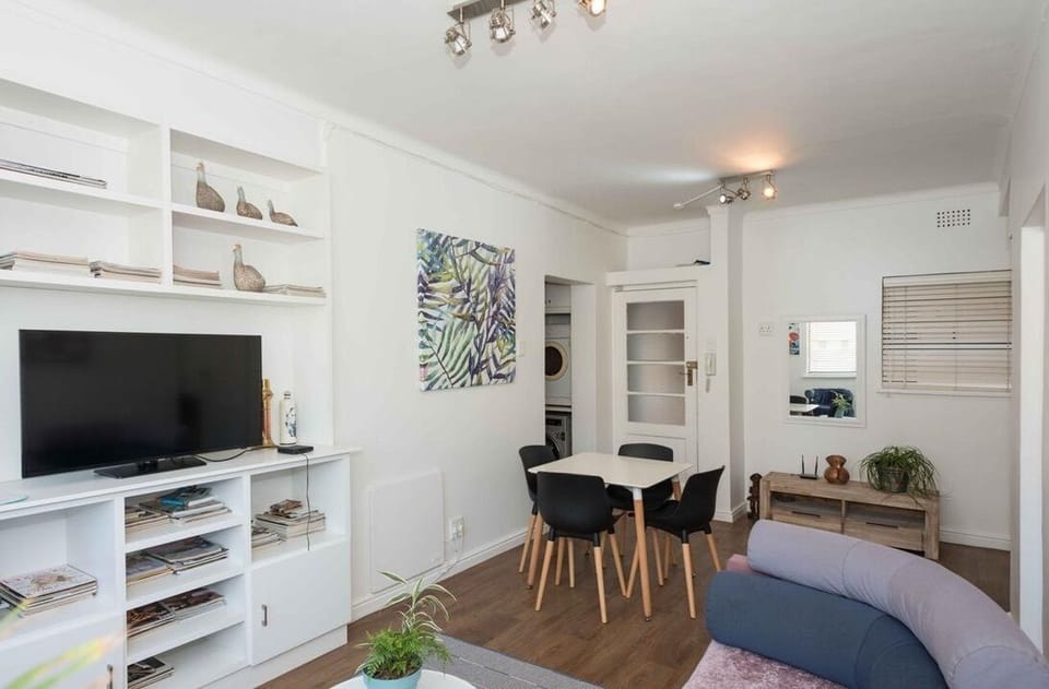 Bright open-plan lounge and dining area with TV and stylish modern decor