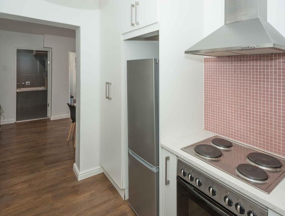 Modern kitchen with stainless appliances, bright finishes, and stylish backsplash