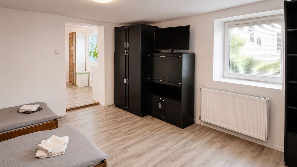 Bright twin bedroom with TV, wardrobes, and plenty of space