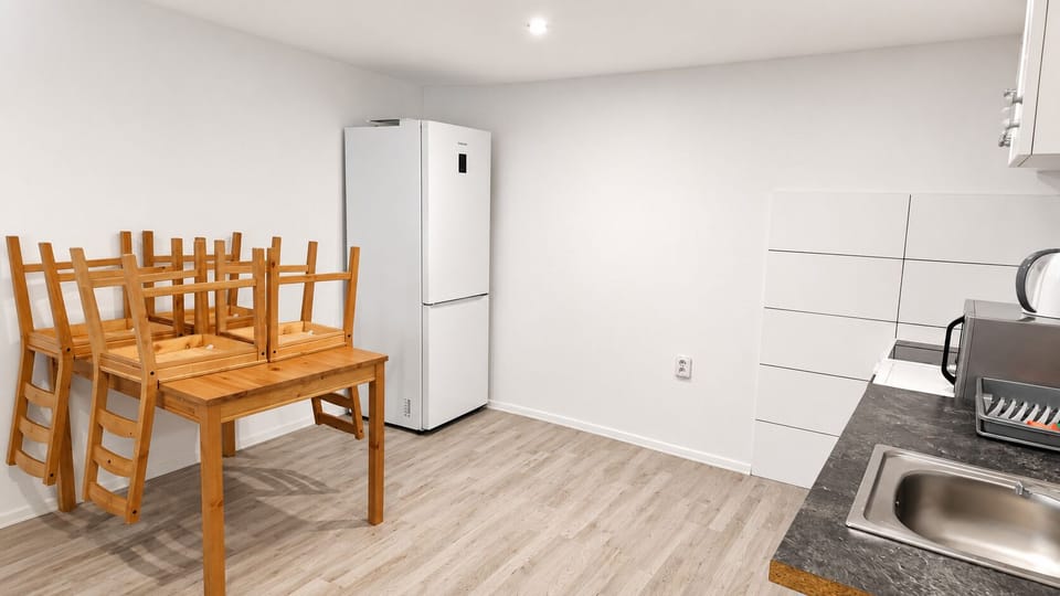 Bright, simple kitchen-dining space with full fridge and cozy table