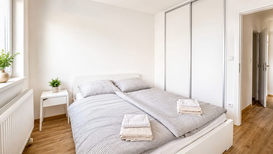 Bright minimalist bedroom with double bed and spacious built-in wardrobe