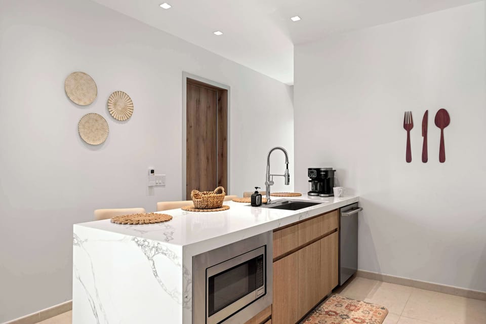 A spacious kitchen island with the sink, microwave, and plenty of prep space all in one place