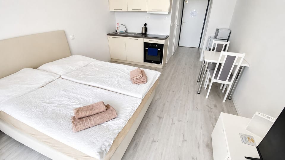 Bright studio with kitchenette, dining nook, and cozy double bed