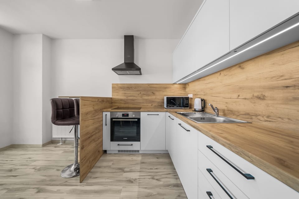 Modern kitchen with breakfast bar, sleek finishes, and full essentials