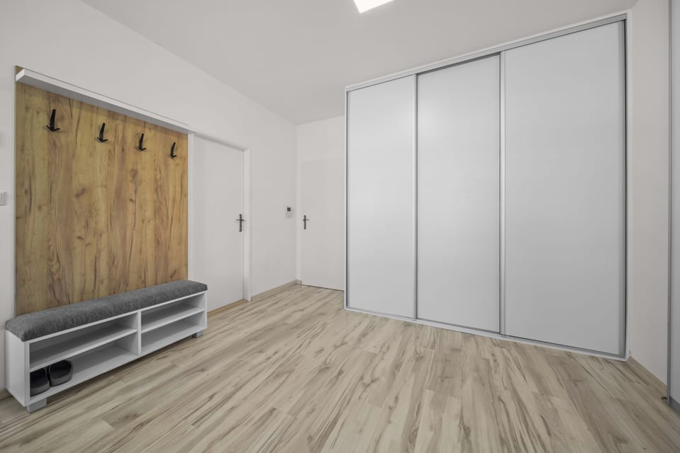 Bright entryway with built-in bench, shoe storage, and large wardrobe