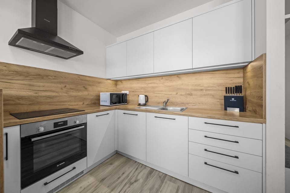Modern, fully equipped kitchen with sleek finishes and warm wood accents