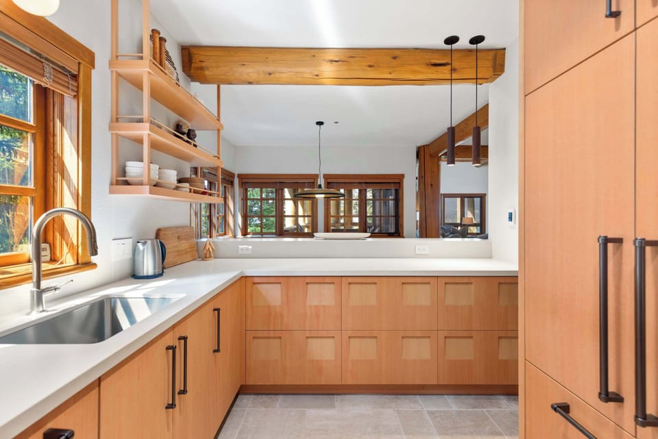 - Modern kitchen with sleek design and wood accents - Fully equipped gourmet kitchen for mountain dining experience - Bright open layout with forest views and natural light