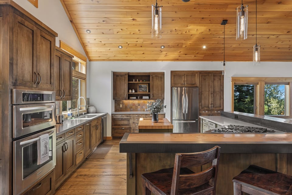 Spacious kitchen with rich wood cabinetry and island seating.