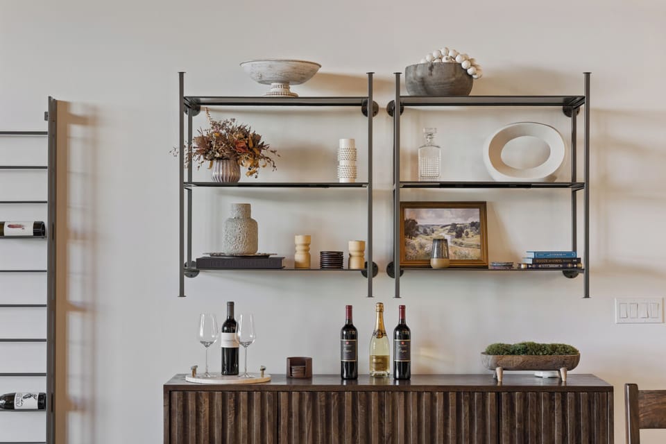 Your stylish bar area awaits—beautifully curated shelving displays elegant glassware and decor, while the sideboard below invites you to pour a glass and unwind in sophisticated comfort.