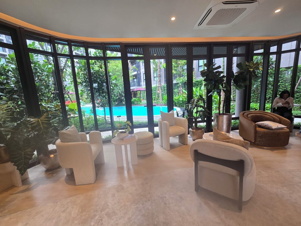 Elegant garden-view lounge with floor-to-ceiling windows by the pool
