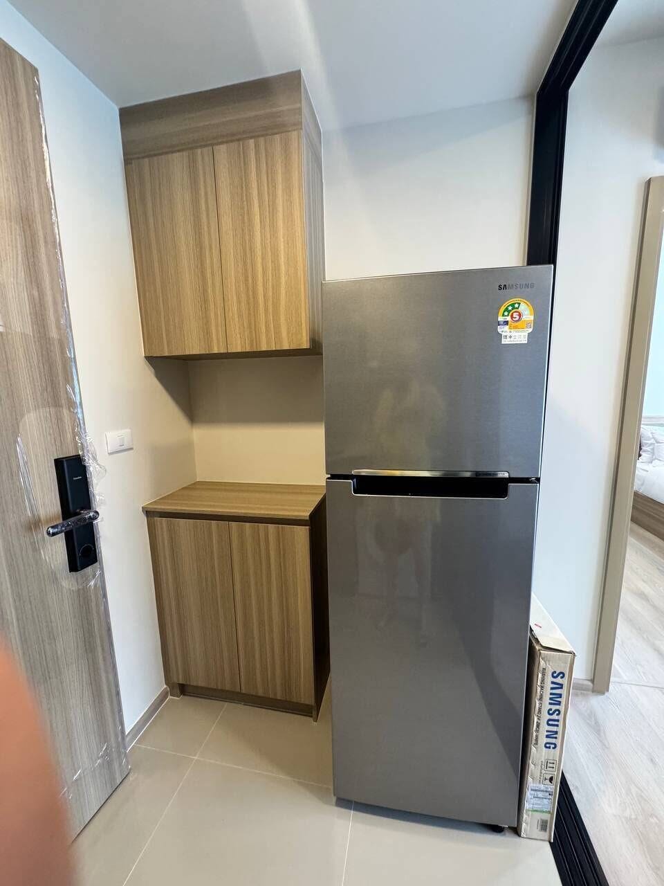 Modern kitchenette nook with full-size fridge and built-in storage