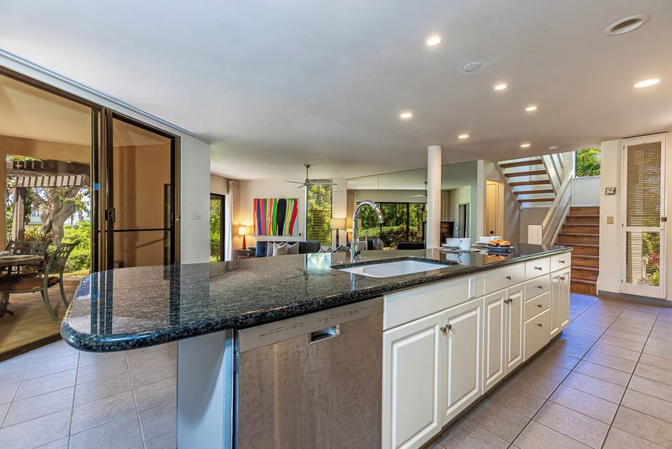 The kitchen flows seamlessly into bright, open living spaces and out to a lush, private patio—perfect for preparing meals while staying connected.