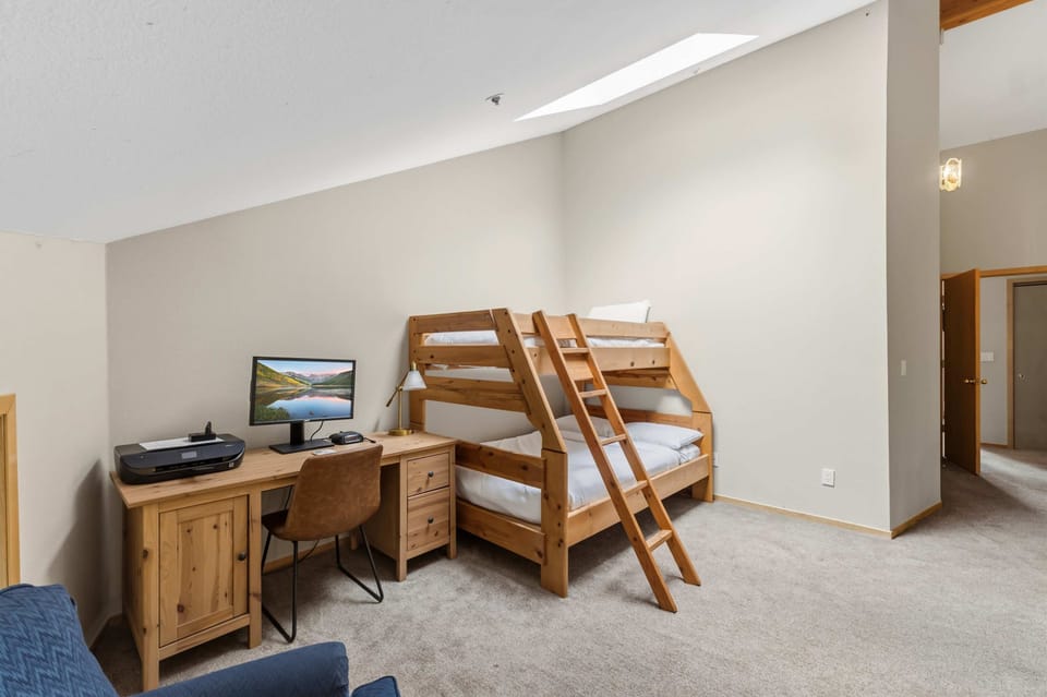 Loft (upper floor): Dedicated workspace with desk and monitor, twin-over-queen bunk bed

