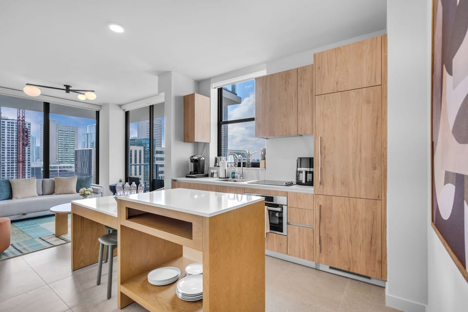 The heart of the home. This bright, open-concept space connects the fully equipped kitchen with the living area, allowing you to cook, dine, and relax while enjoying panoramic city views