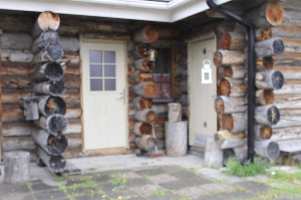 Sheltered log entrance leading to the apartment`s own front door.