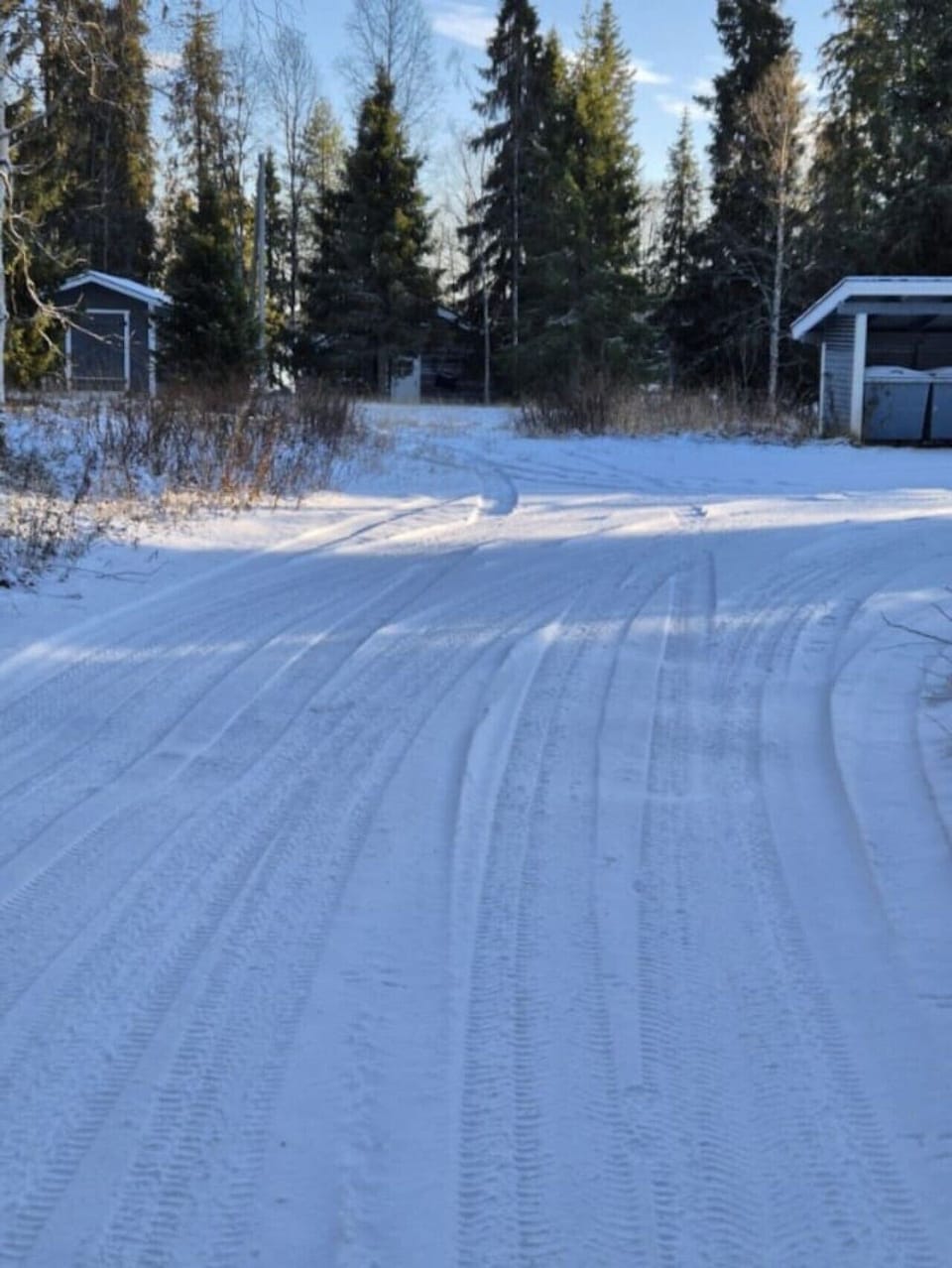 Plowed driveway and parking area beside the property in winter.