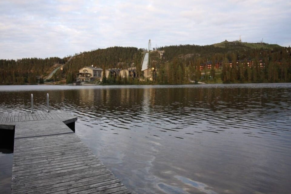 Lake view from the shore with a pier and the fell in the distance.