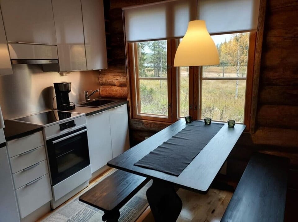 Fully equipped kitchen with an induction stove, oven and coffee maker beside the dining table.