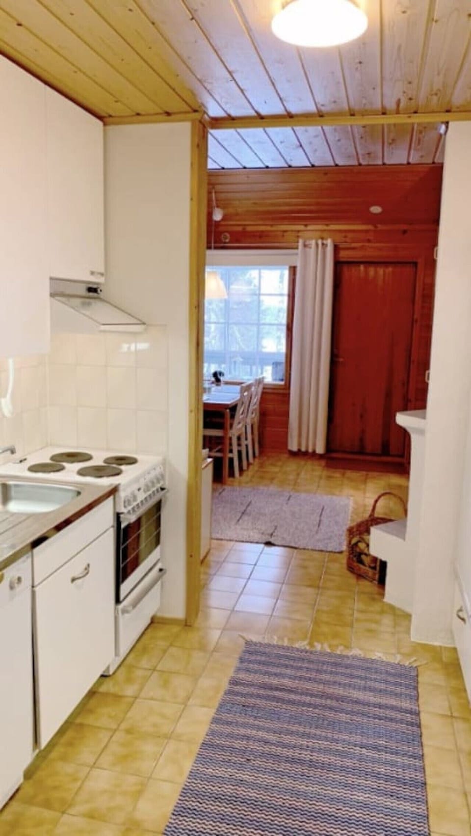 Kitchenette with an electric stove and oven, opening onto the dining area.