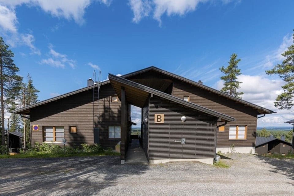 Exterior view of the wooden apartment building and its entrance in summer.