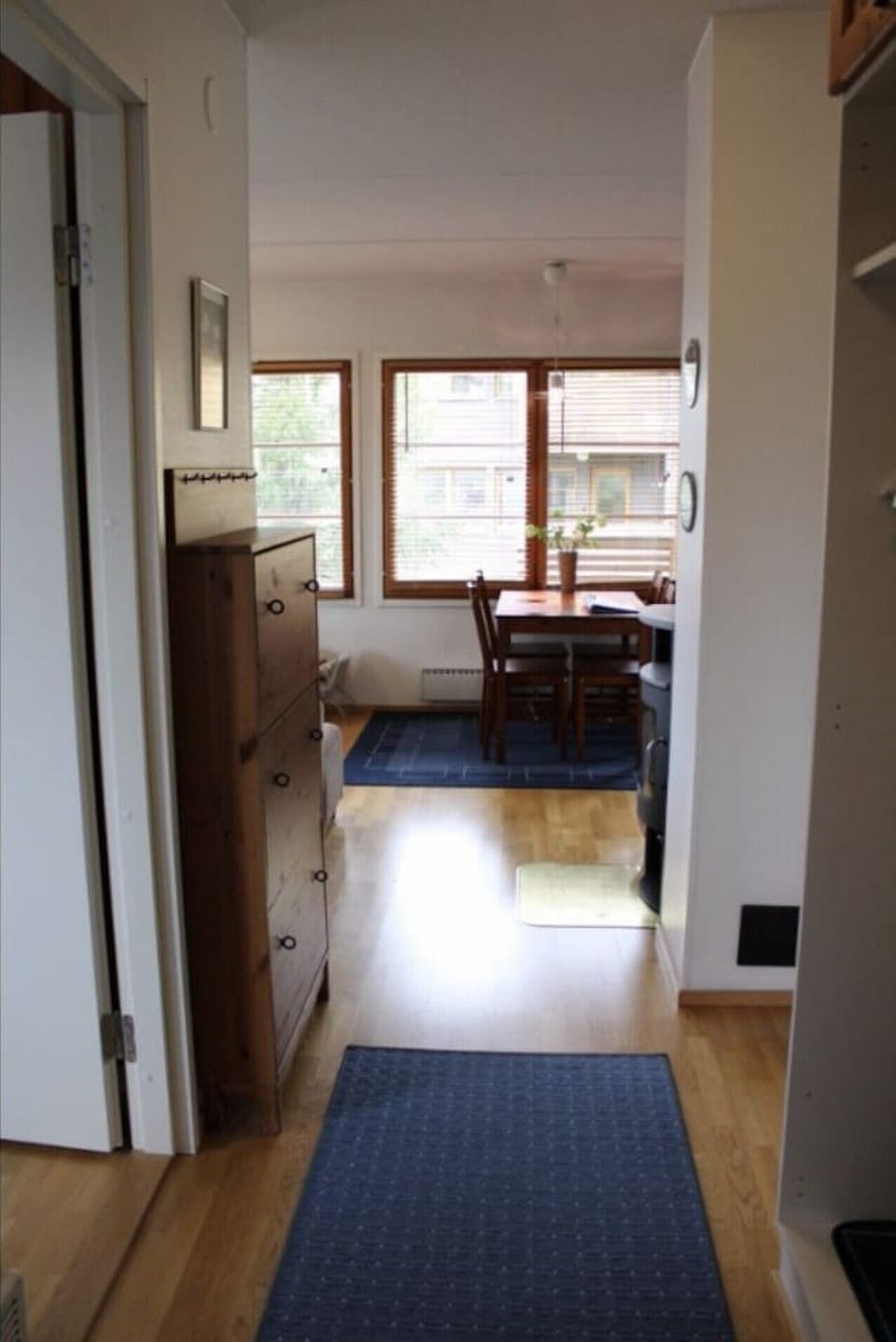 Entrance hallway with coat hooks and storage, opening into the dining area.