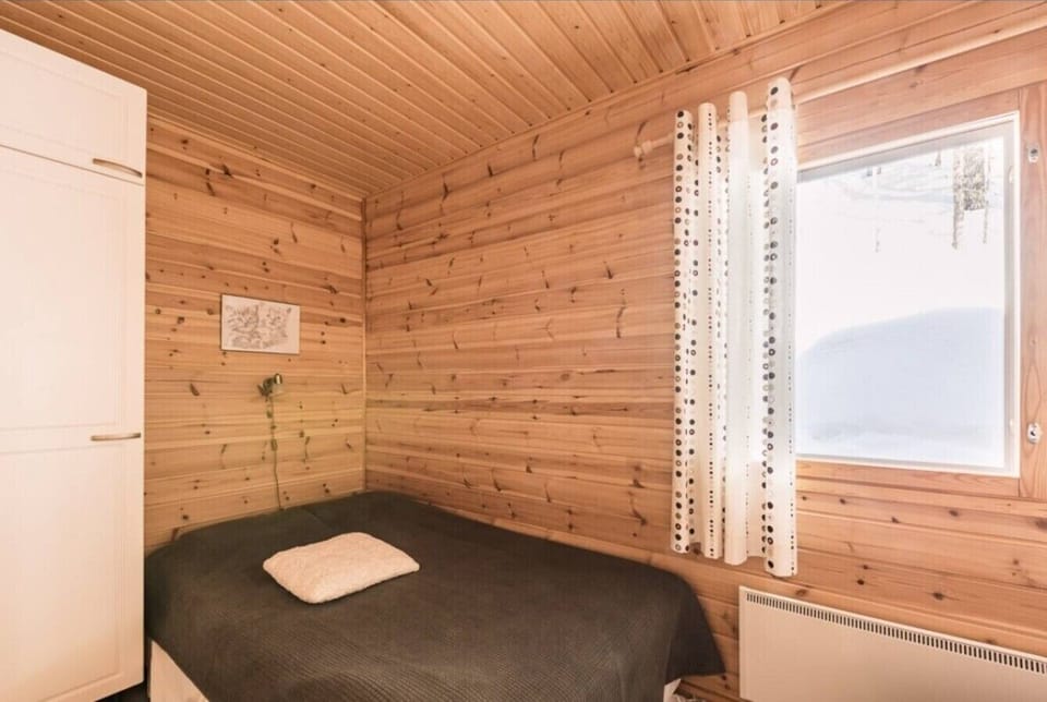 Second bedroom with a comfortable bed, wardrobe storage and a bright window view.