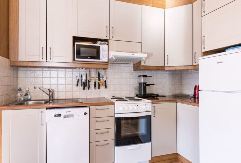 Kitchen equipped with an electric stove and oven, microwave, dishwasher, refrigerator and coffee maker.