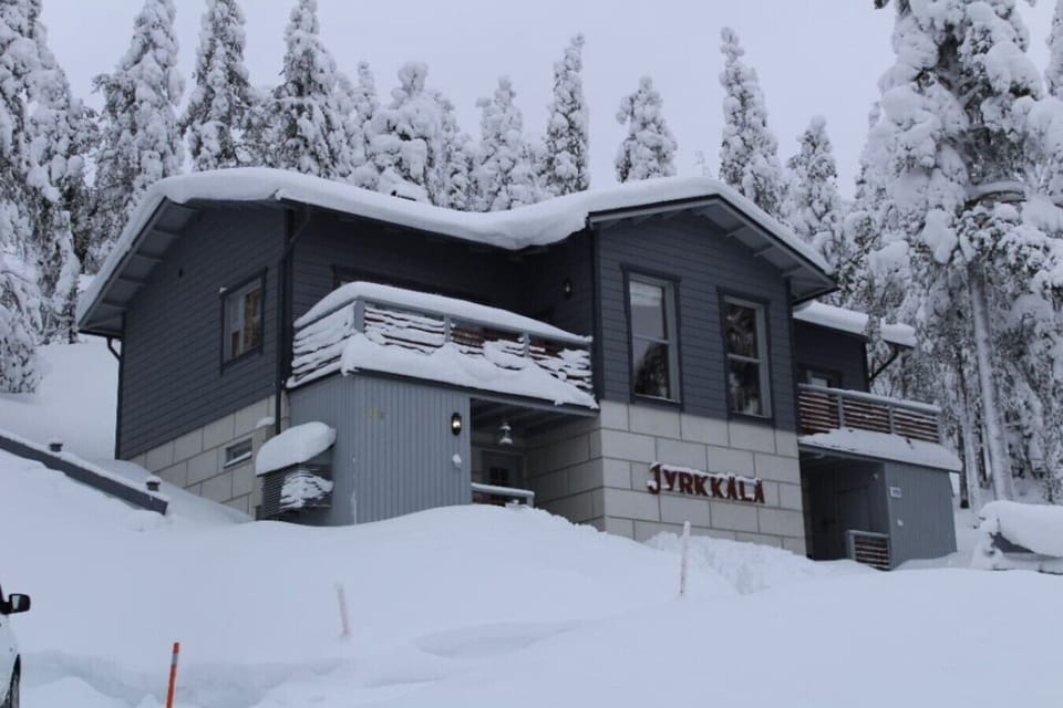 Exterior of the property in winter, surrounded by deep snow and frosted trees.