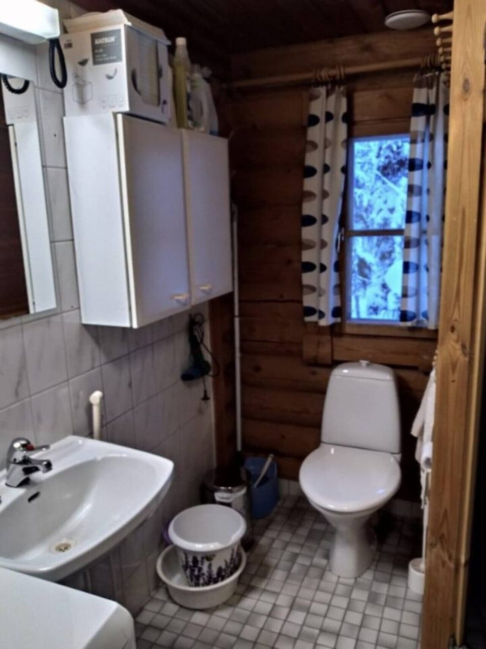 Washroom with a toilet, washbasin and mirrored cabinet.