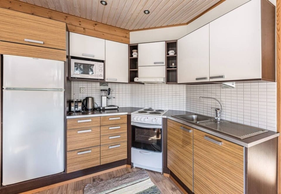 Fully equipped kitchen with an electric stove and oven, fridge-freezer, microwave, coffee maker and kettle.