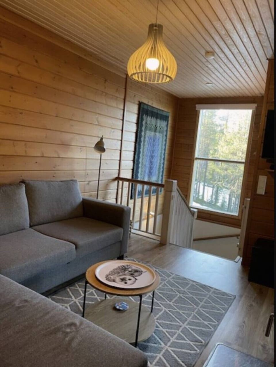 Bright living room with a comfortable corner sofa, coffee table and forest views.