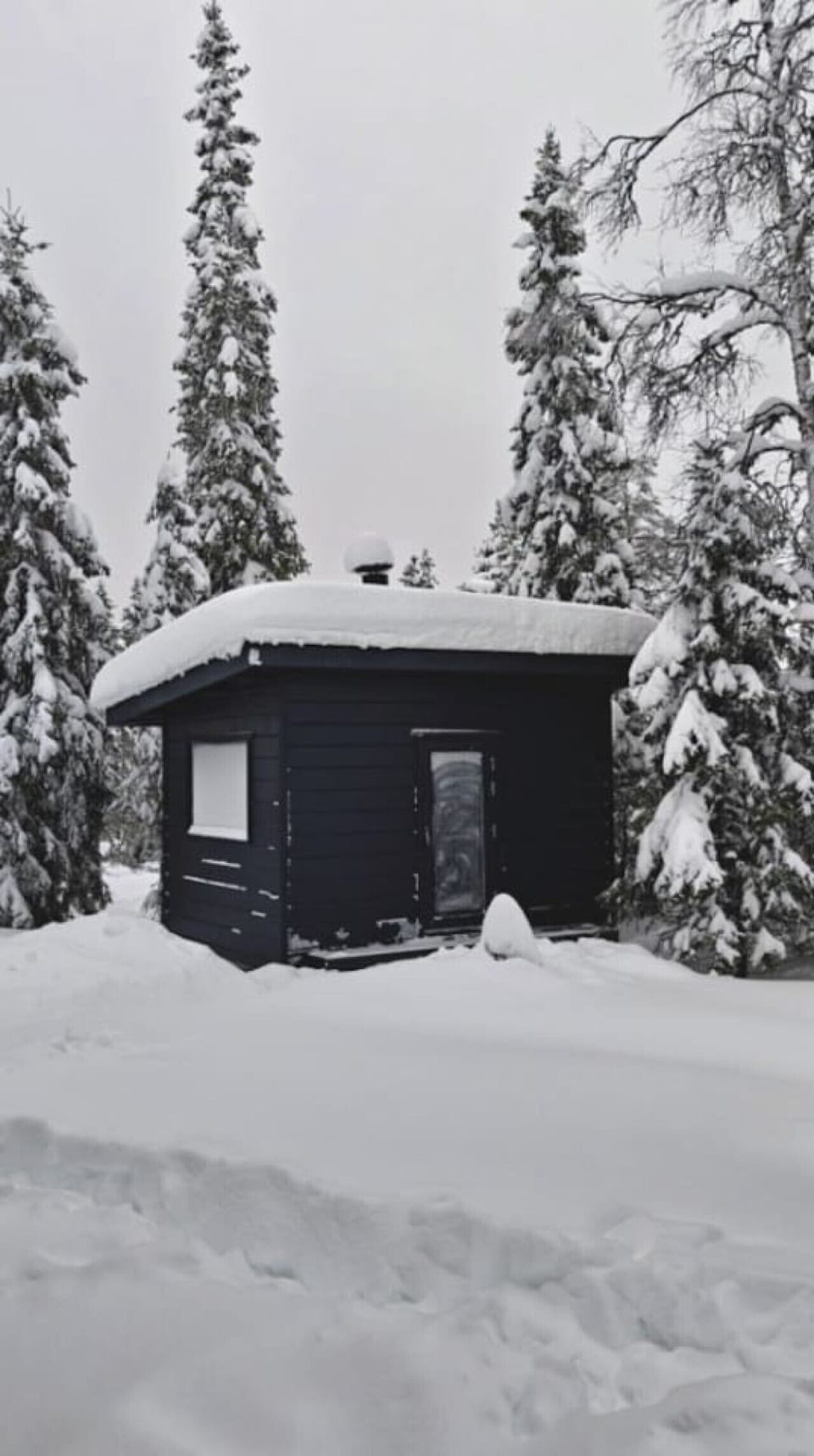 The separate BBQ hut standing in the snow-covered yard.