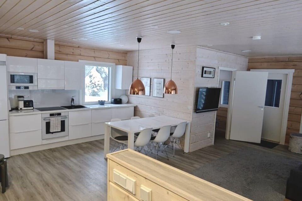 Open kitchen and dining area with a television and a large dining table.