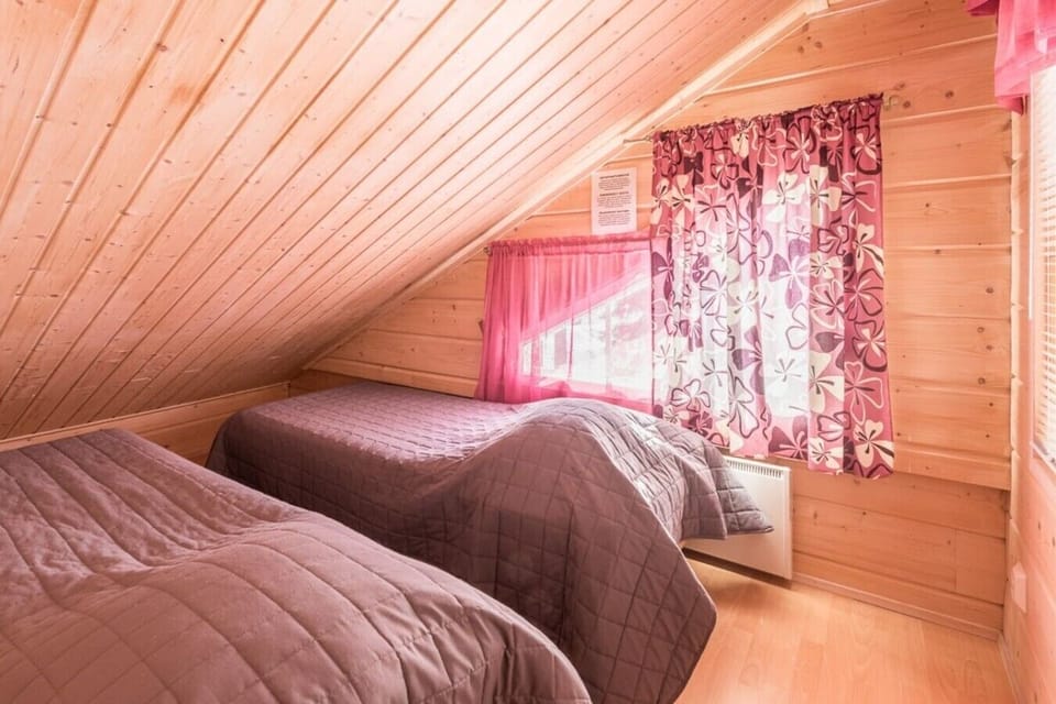 Loft room with two single beds under a sloping wooden ceiling.