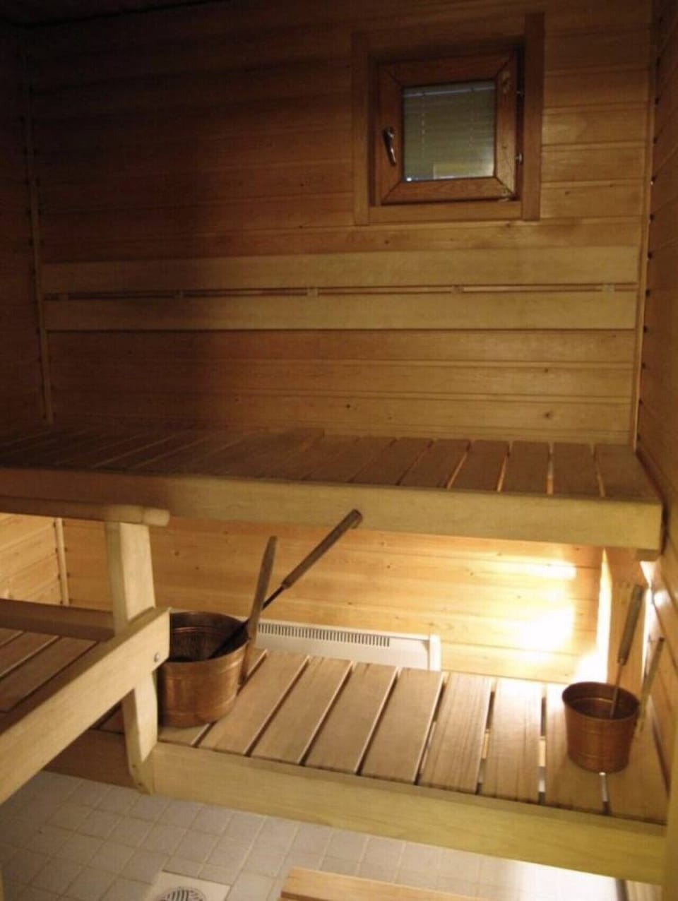 Wood-panelled electric sauna with bench seating.