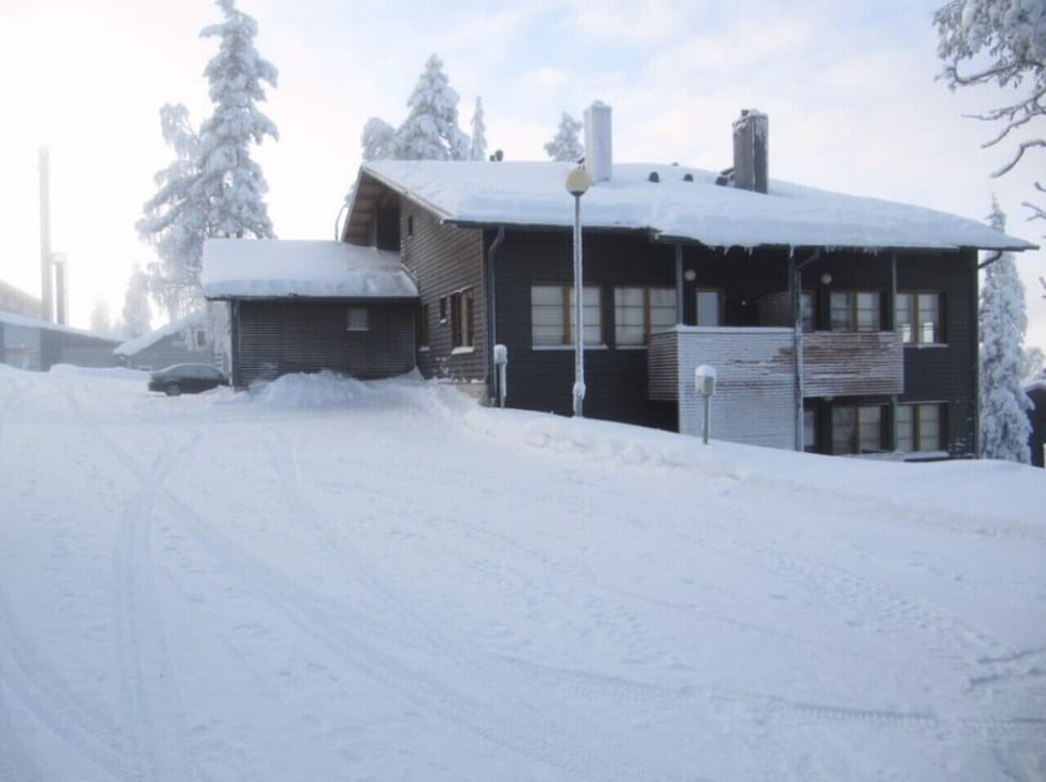 Exterior view of the apartment building and outdoor storage on a snowy winter day.