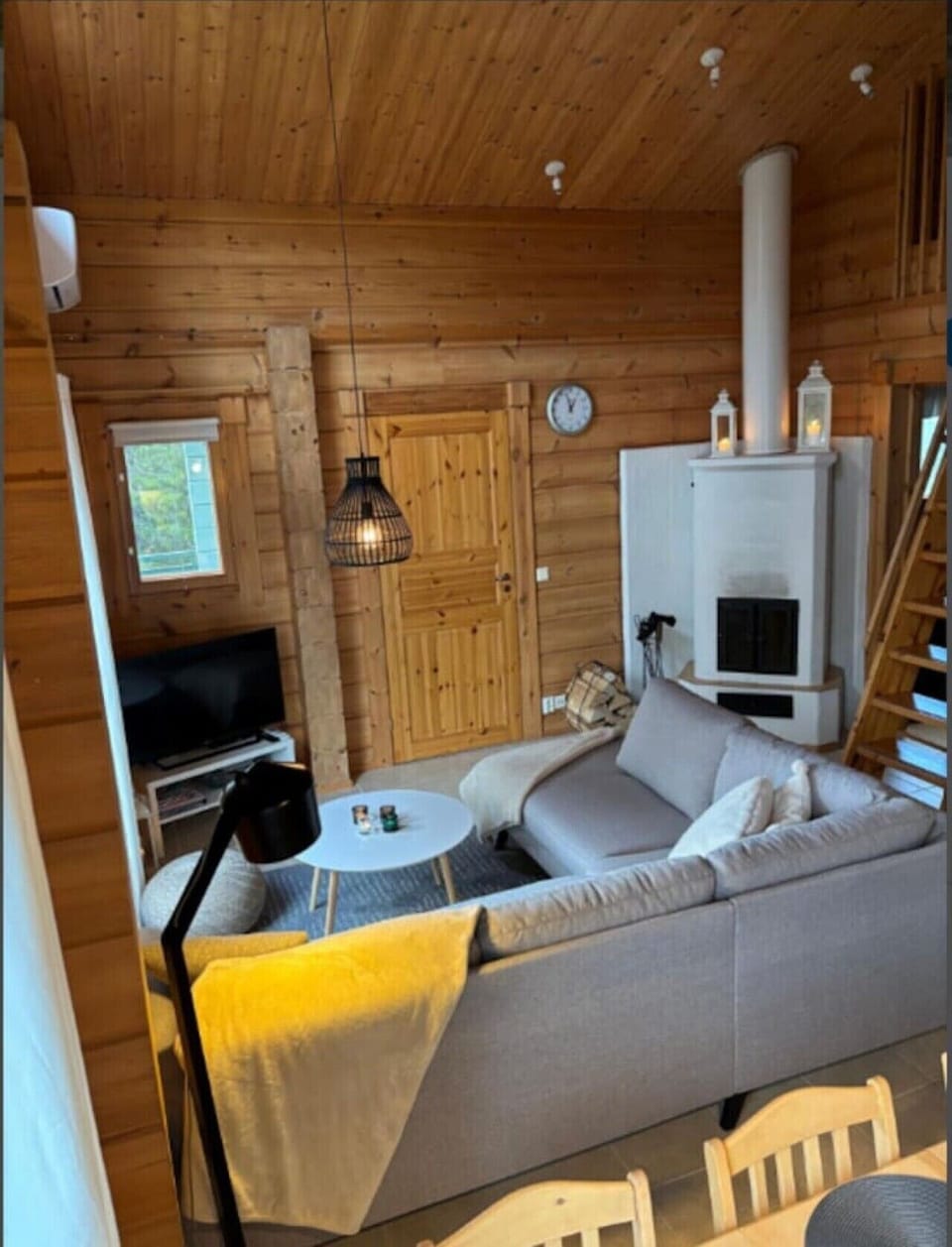 Living room with a white masonry fireplace, sofa seating and a television.