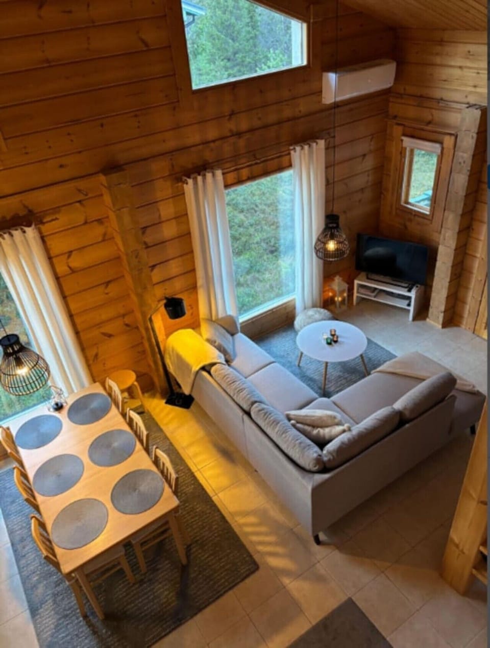 Bright living room with sofa seating, coffee tables and large windows.