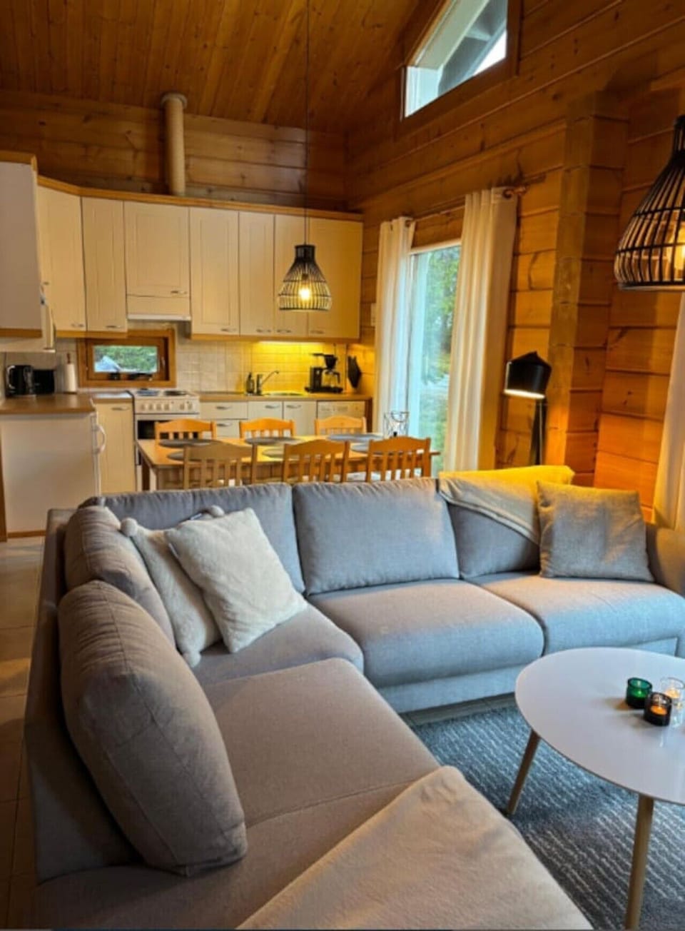 Open-plan living area with a comfortable sofa and the dining table in the kitchen beyond.