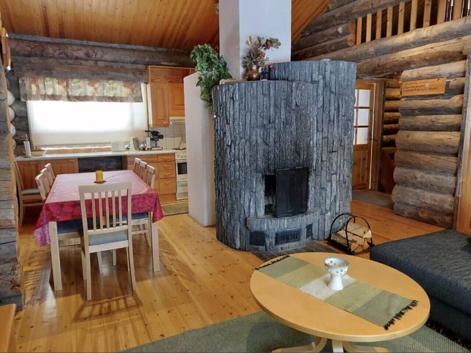 Open dining area beside the kitchen, with a large stone fireplace at its centre.