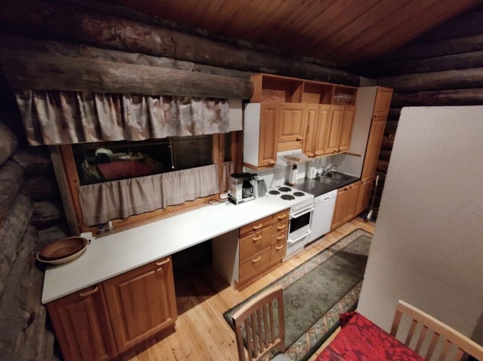 Kitchen with wooden cabinets, generous worktop space and a microwave.