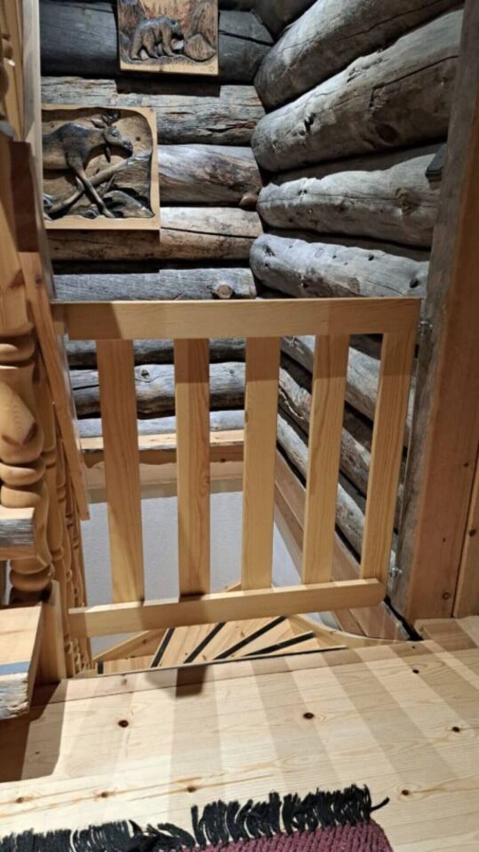 Wooden railing at the top of the loft stairs