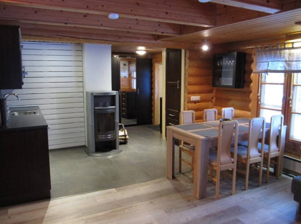 Open-plan kitchen, dining and living space warmed by a fireplace.