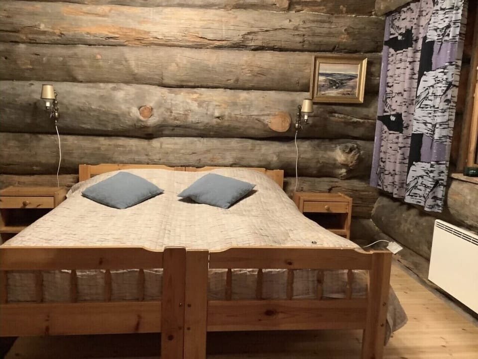 Bedroom with a wooden double bed and a lamp on either side.