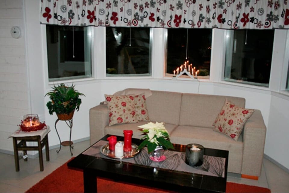 Comfortable living room seating area with a sofa and coffee table by the windows.