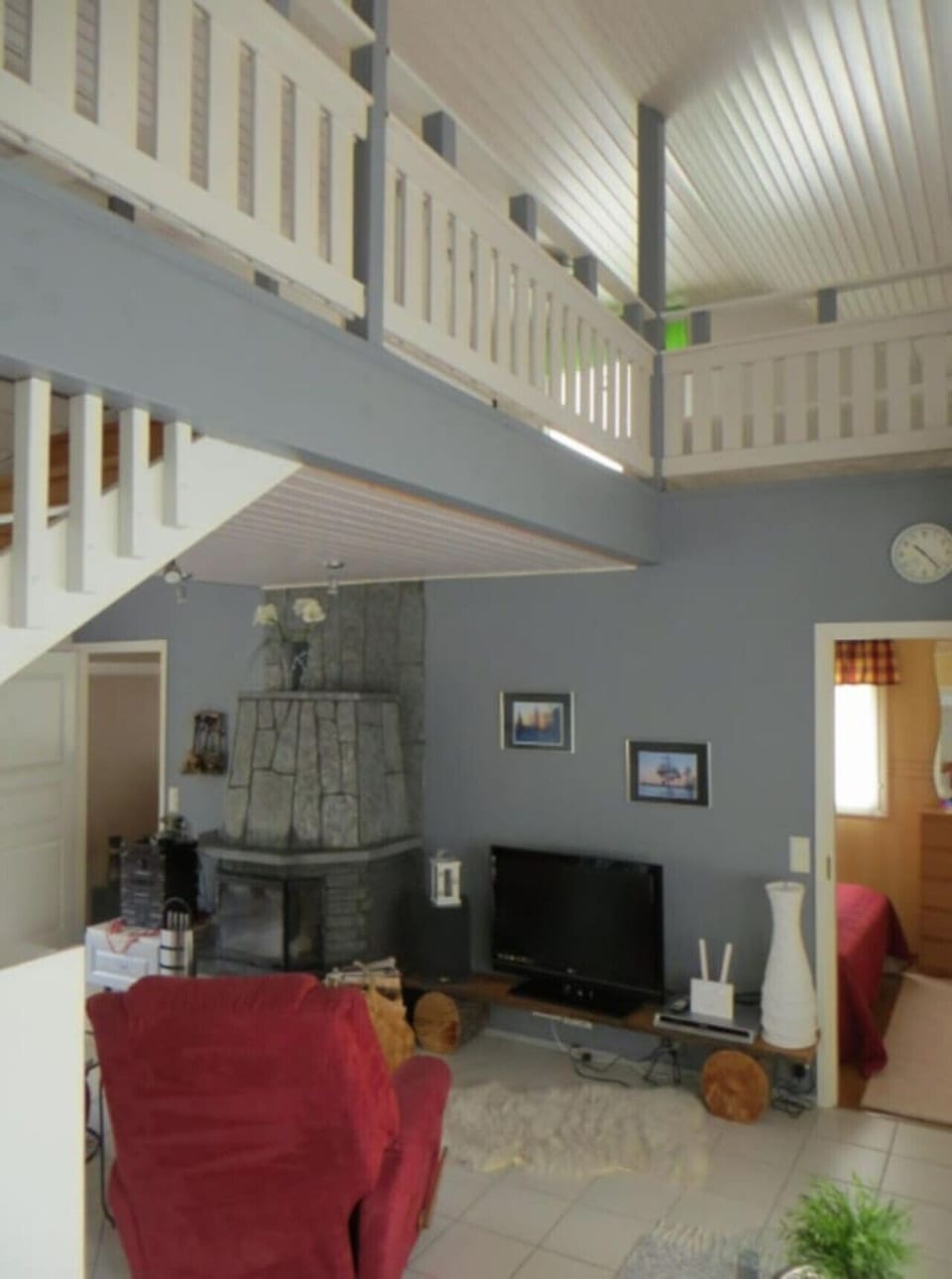 Open living space with a stone fireplace and the loft level above.