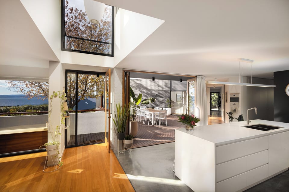 The home's light-filled interiors create a warm, welcoming ambience, with expansive glazing making the most of the elevated setting.
