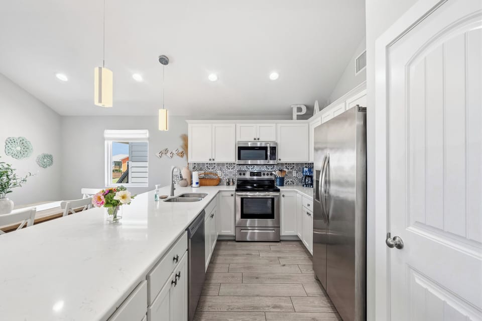 Your fully equipped kitchen awaits with gleaming stainless appliances, plenty of counter space, and thoughtful touches like fresh flowers to make meal prep feel effortless and enjoyable.