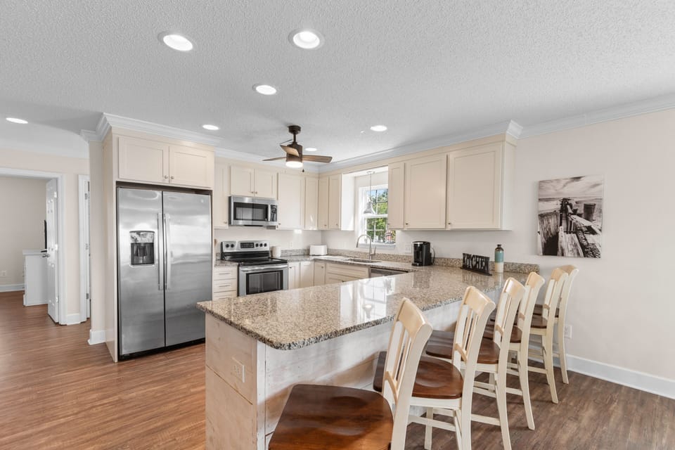 Your spacious kitchen features gleaming granite counters, stainless steel appliances, and a breakfast bar where you can enjoy morning coffee together.